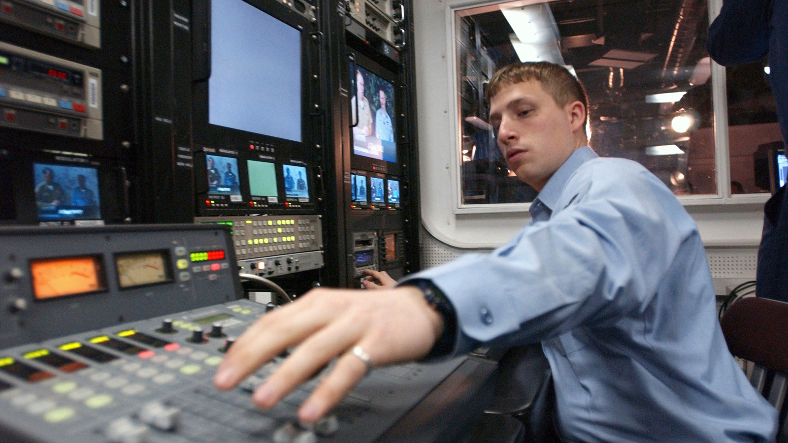 Broadcast technician adjusting microphone levels during a live radio transmission