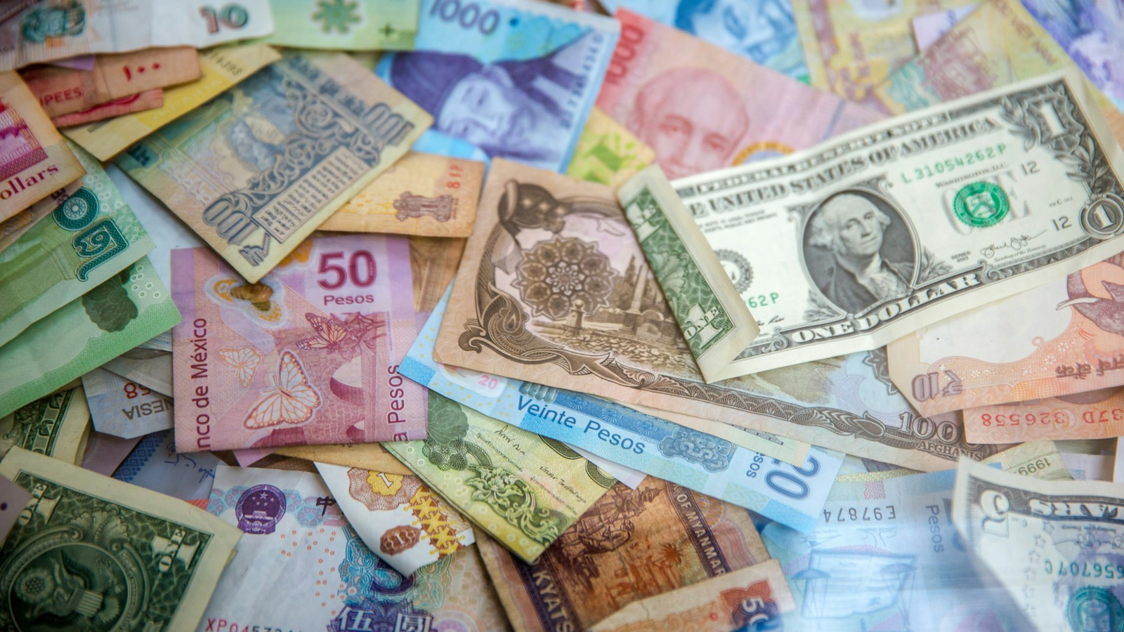 Pile of international banknotes including dollars and other currencies