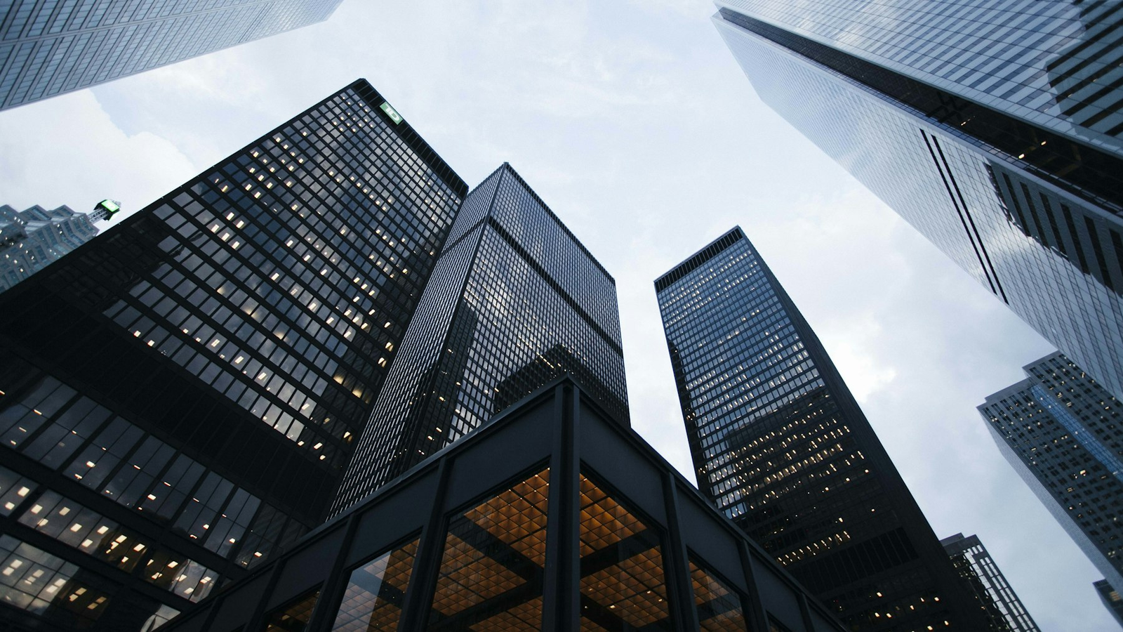 Looking up at illuminated glass skyscrapers in a financial district