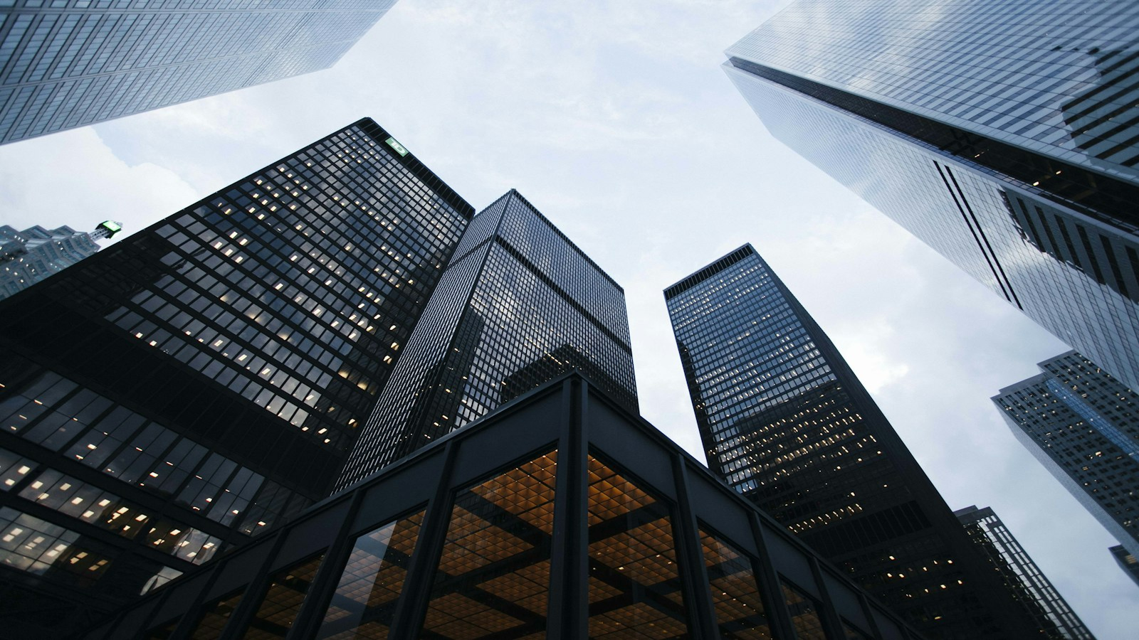 Looking up at tall glass skyscrapers against a clear blue sky