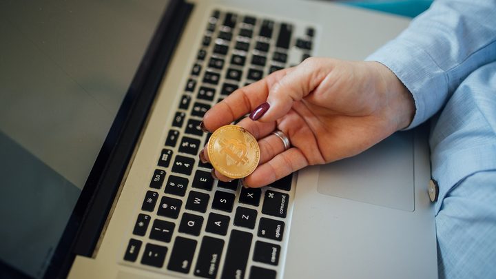 Bitcoin coin above a laptop