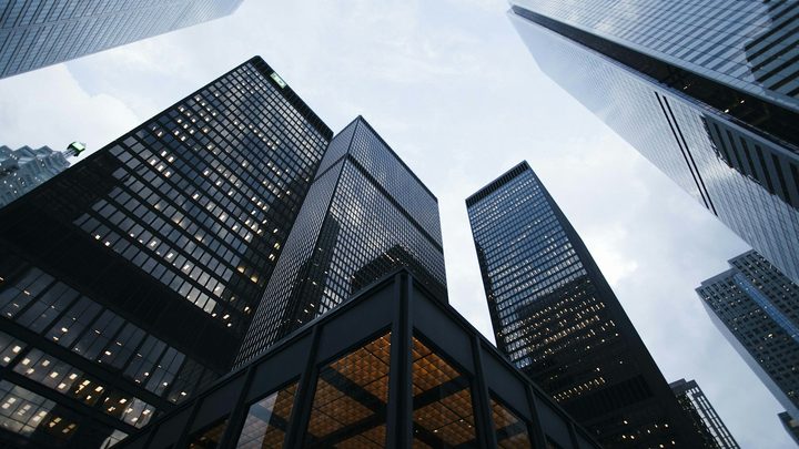 Looking up at illuminated glass skyscrapers in a financial district