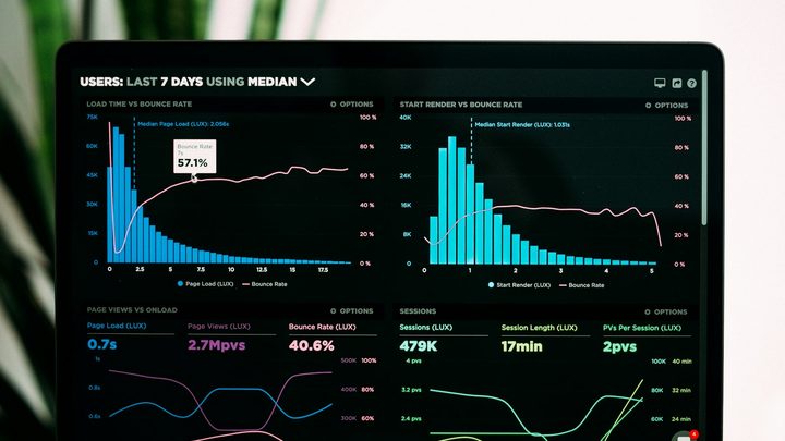 Laptop screen showing a dark-mode analytics dashboard with neon charts