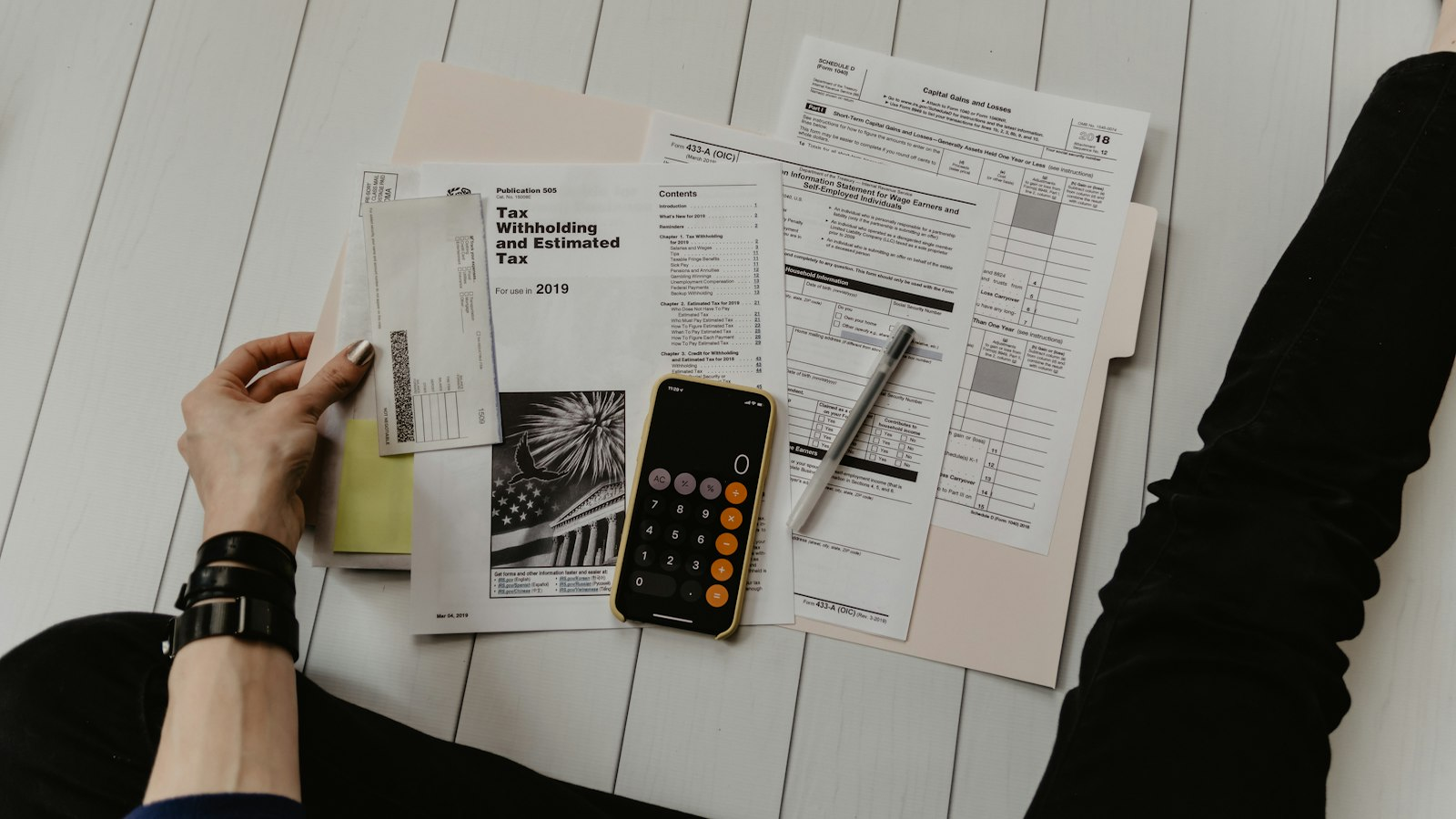 Calculator and financial paperwork spread across a wooden desk